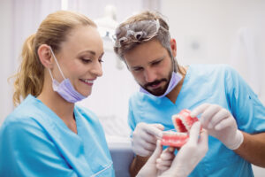 Dentists having discussion on teeth model at dental clinic